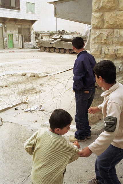 Palestinski otroci zmerjajo izraelske vojake, ki so se s svojimi tanki in oklepniki razmestili po mestu. Palestinski otroci zmerjajo izraelske vojake, ki so se s svojimi tanki in oklepniki razmestili po mestu.