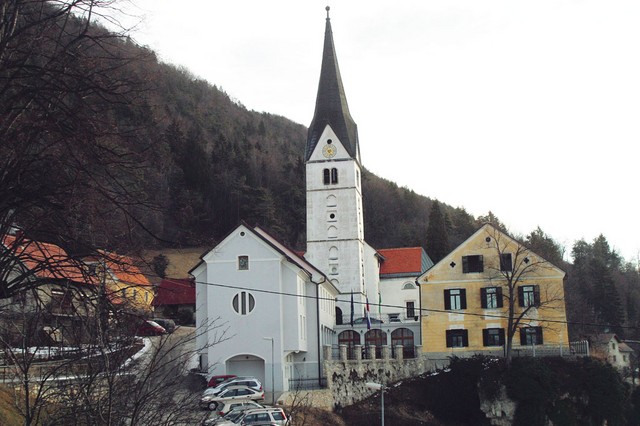 Krstnikov dom, bela zgradba pred cerkvijo