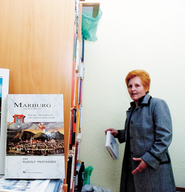 Veronika Haring pred društveno knjižno polico; v ospredju Pertasskova knjiga o nemški zgodovini Maribora Veronika Haring pred društveno knjižno polico; v ospredju Pertasskova knjiga o nemški zgodovini Maribora