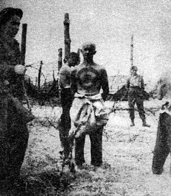Ker je nemški vojak poskušal pobegniti, so ga za kazen obrili do golega, na prsi pa so mu narisali tarčo. (britansko taborišče v Belgiji)