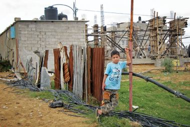 Abdalah al Samuni, ki je v pokolu izraelskih vojaških sil izgubil 29 članov družine. Levo v ozadju je betonska baraka, v kateri prebiva že dve leti, medtem ko pred njo poteka gradnja novega doma. 