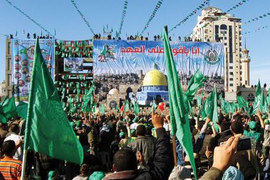 Pozdrav Ismailu Haniji, vodji Hamasa. V nebo iztegnjen desni kazalec pomeni &raquo;Bogu pripadamo!&laquo;. Proslava ob 23. obletnici ustanovitve Hamasa, mesto Gaza. 