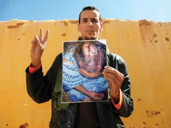 Mohamed Salem s fotografijo svoje sestre, ki so jo pretepli maroški policisti.